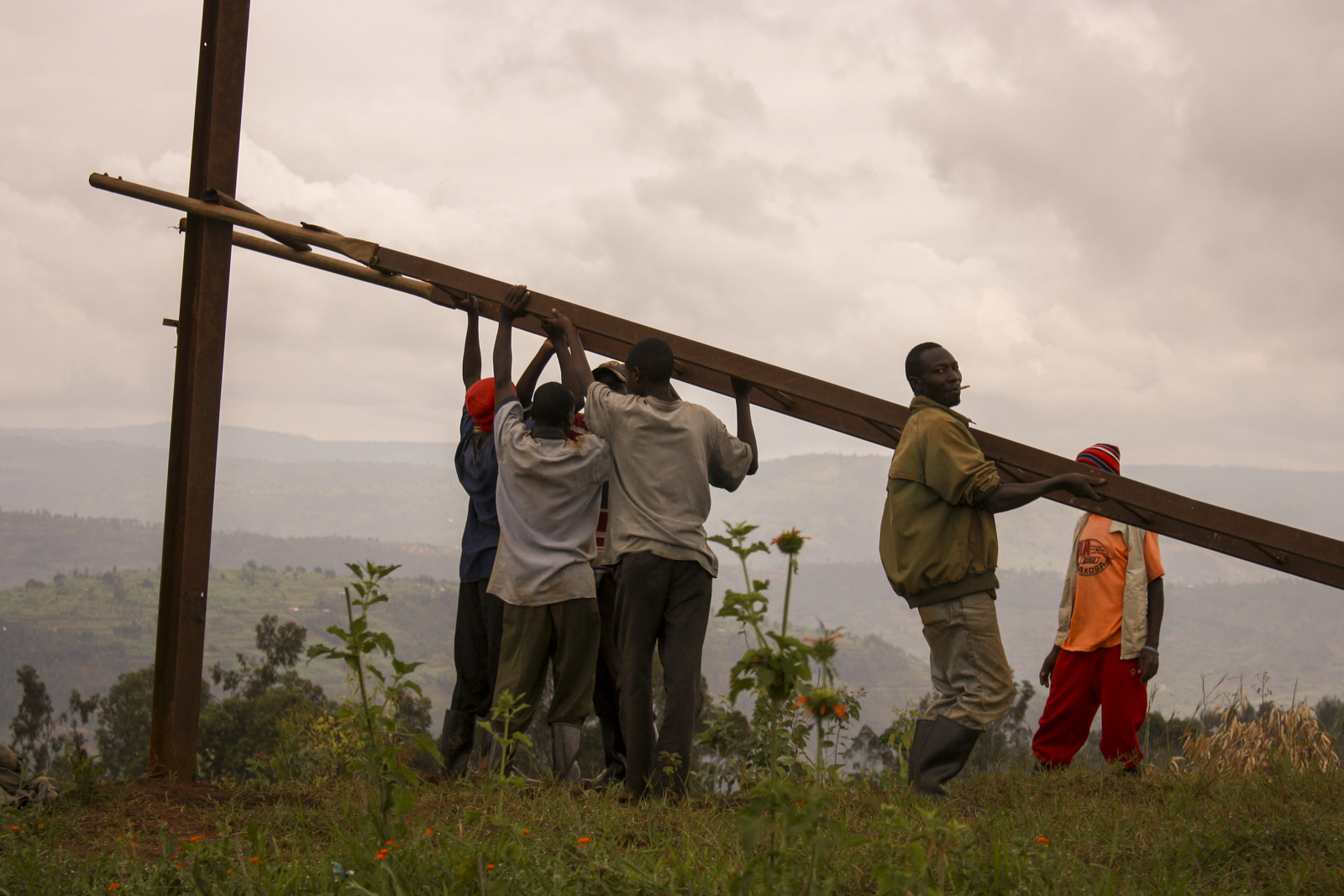 Un gruppo di operai è al lavoro per la sistemazione di un traliccio della corrente nell’area rurale nei dintorni di Murambi, Provincia Settentrionale.